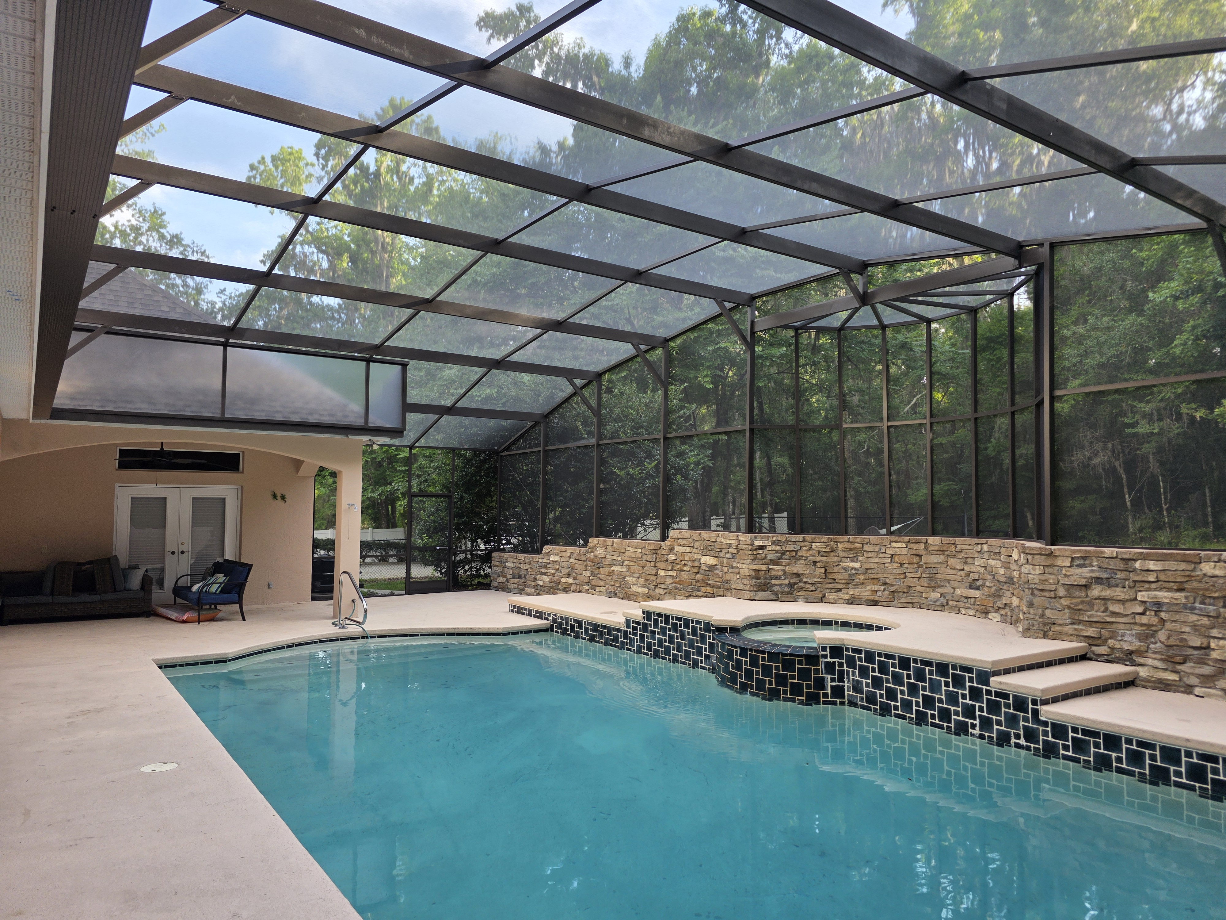 Florida pool enclosure with screened aluminum framework surrounding a backyard pool